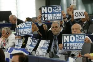 Members of the European Parliament hold placards which reads "No - Freedom to Greece" ahead of the speech of Greek Prime Minister Alexis Tsipras at the European Parliament in Strasbourg