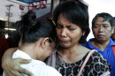 A survivor, left, of the ill-fated passenger ferry MV Thomas Aquinas, is comforted by a relative outside the ticketing office of a shipping company, Saturday Aug. 17, 2013, a day after the ferry collided with a cargo ship, the MV Sulpicio Express Siete, off the waters of Talisay city, Cebu province in central Philippines. Divers combed through the sunken ferry Saturday in search of dozens of people missing after the collision that sent passengers jumping into the ocean and leaving many others trapped. At least 31 were confirmed dead and hundreds rescued. (AP Photo/Bullit Marquez)