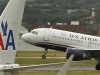 A US airways plane takes off behind an American Airlines jet at Ronald Reagan National Airport in Washington