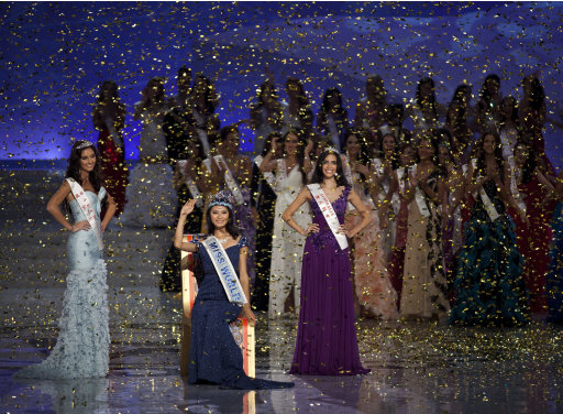 Newly crowned Miss World Yu Wenxia of China, center, waves flanked by first runner-up Miss Wales, Sophie Moulds, left, and 2nd runner-up Miss Australia Jessica Kahawaty, right, during the Miss World 2012 beauty pageant at the Ordos Stadium Arena in inner Mongolia, China Saturday, Aug. 18, 2012. (AP Photo/Andy Wong)