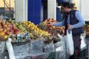 Un uomo sceglie della frutta in un mercato romano