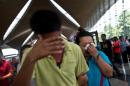 A woman (R) breaks down while leaving the reception centre for families and friends of passengers on a missing Malaysia Airlines jet at the Kuala Lumpur International Airport on March 8, 2014