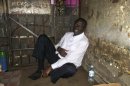 Ugandan opposition leader Kizza Besigye sits in a police cell in capital Kampala