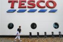 A shopper passes a Tesco supermarket in London