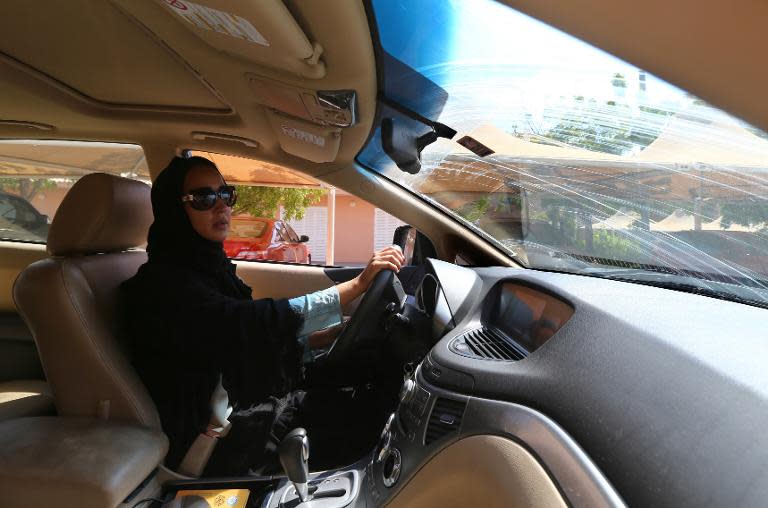 Saudi activist Manal Al Sharif, who now lives in Dubai, drives her car in the Gulf Emirate city on October 22, 2013, as she campagins in solidarity with Saudi women