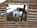 People walk by a burnt-out house in Caldono, in the province of Cauca