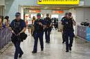 Armed police officers walk in front of the arrival gate at Heathrow airport, west of London on July 23, 2012