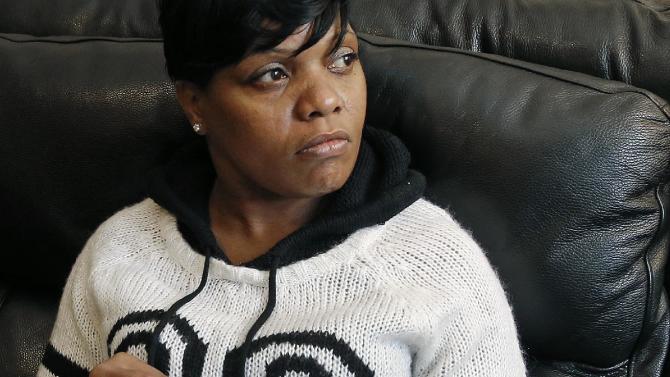 In this Dec. 11, 2014 photo, Terri Scroggins holds the memorial program for her fiance, Victor Woods, at her home in Boston&#39;s Dorchester neighborhood. Woods, who had struggled with heroin addiction for years, was being held on a drug possession charge at New York City’s Rikers Island jail when he began shaking violently and convulsing. He died hours later. What exactly killed him remains under investigation, as are inmate claims that both guards and medical workers took up to 20 minutes to start helping him. (AP Photo/Elise Amendola)