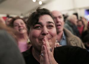 A woman reacts as she watches the exit poll results …