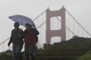 Women walk under an umbrella in front of the Golden Gate Bridge at the Marin Headlands in Marin County, Calif., Thursday, Nov. 29, 2012. The National Weather Service says that by late morning Thursday 1 inch of rain had fallen in several hours across the western side of the county. Much of Northern California is under a variety of warnings and advisories for rain, snow and high winds. (AP Photo/Jeff Chiu)