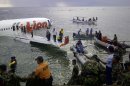 This photo released by Indonesia's National Rescue Team shows rescuers at the crash site of a Lion Air plane in Bali, Indonesia on Saturday, April 13, 2013. The plane carrying more than 100 passengers and crew overshot a runway on the Indonesian resort island of Bali on Saturday and crashed into the sea, injuring nearly two dozen people, officials said. (AP Photo/National Rescue Team)