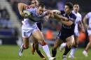 England's Kevin Sinfield (C) holds off France's Morgan Escare (R) and Eloi Pelissier during a 2013 Rugby League World Cup quarter-final match at the DW Stadium in Wigan, northwest England on November 16, 2013
