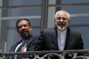 Iranian Foreign Minister Mohammad Javad Zarif, right, talks to journalist from a balcony of the Palais Coburg hotel where the Iran nuclear talks are being held in Vienna, Austria, Friday, July 10, 2015. (Carlos Barria/Pool via AP)