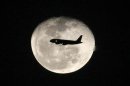 A passenger jet flies in front of the moon in Bogota