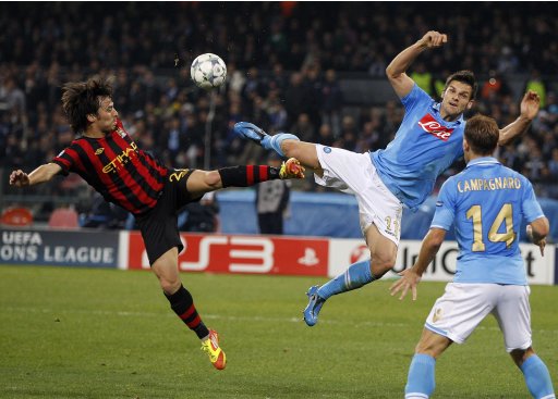 Manchester City's Silva and Napoli's Maggio jump for the ball during their Champions League soccer match in Naples