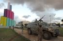Libyan security members stand by an armored personnel carrier as they patrol the streets of Benghazi on November 14, 2013