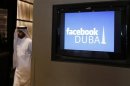 A man walks past a screen during a news conference announcing the opening of Facebook offices in Dubai