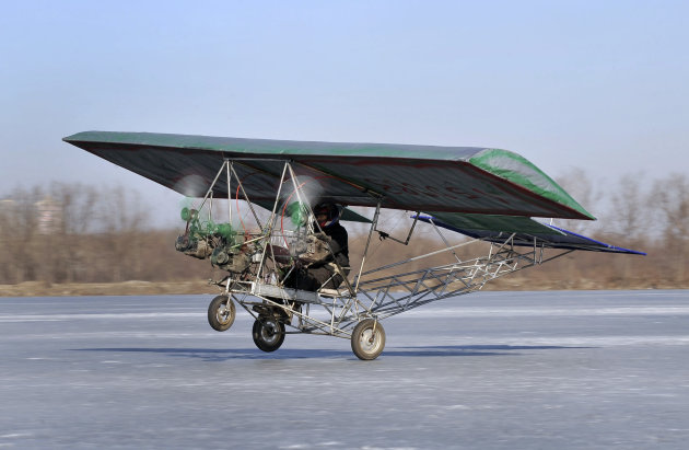 Ding Shilu, an automobile mechanic, carries out a test-flight for his self-made aircraft at a frozen reservoir in Shenyang,
