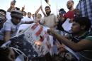 Protesters burn a replica of the U.S. flag during a protest against the capture of Liby in Benghazi