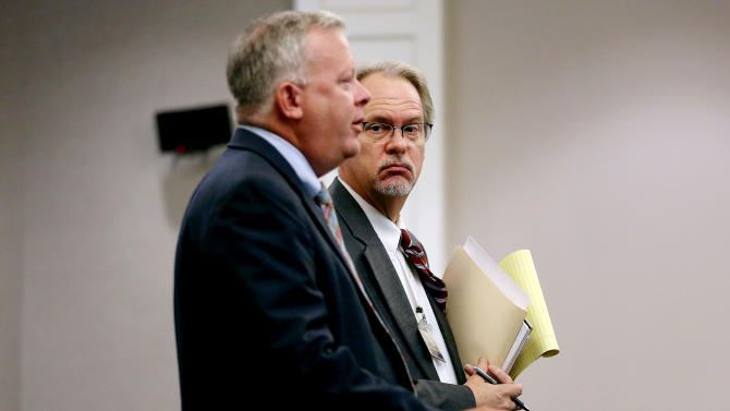 Public Defenders Bill McGuire, left, and Ashley Pennington speak with 9th Circuit Judge J.C. Nicholson on Wednesday, Sept. 16, 2015 during a hearing on a gag order in Dylann Roof&#39;s prosecution at the Charleston County Courthouse in Charleston, S.C.  Nicholson said he wanted to sit down with attorneys for the victims and the news media to review some of the more graphic evidence — including photographs of the crime scene, before deciding specifically what will be released.  (Grace Beahm/The Post And Courier via AP) MANDATORY CREDIT