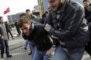Plain clothes police officers detain an anti-government protester at Taksim square in central Istanbul
