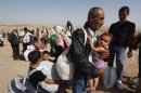 Syrian refugees, fleeing the violence in their country, cross the border into the autonomous Kurdish region of northern Iraq