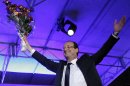 President-elect Francois Hollande holds a bouquet of roses after delivering his speech in Tulle, central France, Sunday, May 6, 2012. Francois Hollande defeated Sarkozy on Sunday to become France's next president, Sarkozy conceded defeat minutes after the polls closed. (AP Photo/Christophe Ena)