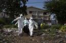 Burial team remove body of suspected Ebola virus victim in Freetown
