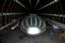 The Aeroscraft airship, a high-tech prototype airship, is seen in a World War II-era hangar in Tustin, Calif., Thursday, Jan. 24, 2013. Work is almost done on a 230-foot rigid airship inside a blimp hangar at a former military base in Orange Co. The huge cargo-carrying airship is has shiny aluminum skin and a rigid, 230-foot aluminum and carbon fiber skeleton. (AP Photo/Jae C. Hong)