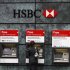 A woman uses a cash point machine at a HSBC bank in the City of London
