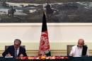 Afghan presidential candidates Abdullah Abdullah (left) and Ashraf Ghani Ahmadzai sign a power-sharing agreement at the Presidential Palace in Kabul on September 21, 2014
