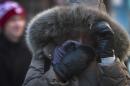 A New York City pedestrian covers up against single-digit temperatures, Tuesday, Jan. 7, 2014. The high is expected to be 10 degrees. But wind chills will make it feel more like minus 10. (AP Photo/Bebeto Matthews)