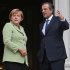 Greece's Prime Minister Antonis Samaras, right, and Germany's Chancellor Angela Merkel speak before their meeting at the Maximos mansion in Athens, Tuesday, Oct. 9, 2012. Amid draconian security measures and a mass protest, German Chancellor Angela Merkel arrived Tuesday for her first visit to Greece since the eurozone crisis began there three years ago. Her five-hour stop is seen by the Greek government as a historic boost for the country's future in Europe, but by protesters as a harbinger of more austerity and hardship.   (AP Photo/Thanassis Stavrakis, Pool)