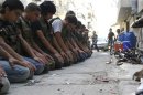 Free Syrian Army fighters pray along a street in Aleppo's Salaheddine neighbourhood