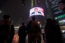 People watch a TV showing of a huge screen shows a news broadcast of China's Vice President Xi Jinping at the 18th Communist Party Congress at a crossroads in Shanghai