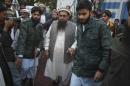 Hafiz Saeed, center, head of religious group Jamaat-ud-Dawa leaves after addressing a rally against caricatures published in French magazine Charlie Hebdo, in Lahore, Pakistan, Sunday, Jan. 18, 2015. Thousands of supporters of hard-line Jamaat-ud-Dawa rallied in eastern city of Lahore against the satirical newspaper Charlie Hebdo and its publication of cartoons depicting the Prophet Muhammad. (AP Photo/K.M. Chaudary)
