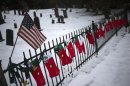 A U.S. flag hangs over stockings left as a memorial for victims of the Sandy Hook Elementary School shooting, along a fence surrounding the Sandy Hook Cemetery in Newtown