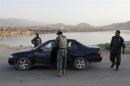 Afghan policemen search a car at a check point in Kabul