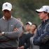 Woods of the U.S. reacts as he stands next to fellow golfer McIlroy of Northern Ireland during trophy presentation after their exhibition event at Jinsha Lake Golf Club in Zhengzhou