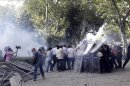 Antidisturbios turcos se escudan tras lanzar bombas de gas lacrimógeno contra los manifestantes durante una protesta contra la planeada construcción de un centro comercial en la Plaza Taksim, en Estambul, Turquía, hoy. EFE