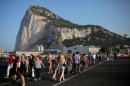 Pedestrians cross the tarmac at Gibraltar International Airport in front of the Rock near the border with Spain in the British overseas territory of Gibraltar