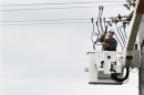 A power company worker in a cherry picker connects wires to a power line while working to restore electricity in East Massapequa
