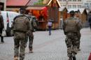 French soldiers patrol past wooden barracks shops during the installation of the traditional Christkindelsmaerik near Strasbourg's cathedral in Strasbourg