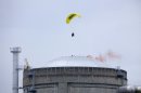 FILE - In this May 2, 2012 file photo provided by Greenpeace, an activist in a motorized paraglider flies over the Bugey nuclear power plant, near Saint-Vulbas, central France, and drops a flare on the roof. Questions are being raised about whether two Russians held on terror charges in Spain were planning to launch airborne attacks on paragliders. The two Russians took paragliding lessons this year in a southern Spanish region renowned for the sport, authorities said over the weekend. A Turkish engineer also under arrest paid for the lessons. No attacks have been carried out using paragliders, experts said. However, paragliding did feature in one recent stunt by an environmentalist that must have given chills to authorities, including those from countries that use drones to target and kill suspected Islamic terrorists. The activist was arrested last May after dropping a billowing smoke bomb onto the roof of a French nuclear reactor. (AP Photo/Lagazta, Greenpeace, File)