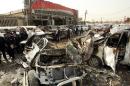 Iraqi policemen arrive to inspect the site of a car bombing that targeted an area of car dealerships on March 7, 2014 in Baghdad