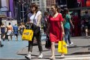 Women carry shopping bags through Times Square in New York