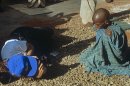 Un reportero gráfico se tumba en el suelo para fotografiar a un niño somalí en la ciudad de Badoia. EFE/Archivo