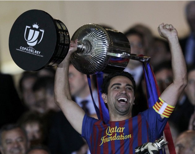 Barcelona's Xavi lifts up the Spanish King's Cup trophy after winning their final soccer match against Athletic Bilbao in Madrid