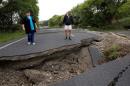 Local residents Chris and Viv Young look at damage caused by an earthquake along State Highway One, south of the township of Blenheim on New Zealand's South Island