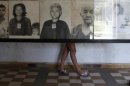 A tourist looks at portraits of victims killed in the former Khmer Rouge regime's S-21 security prison, presently known as Tuol Sleng Genocide Museum, in Phnom Penh